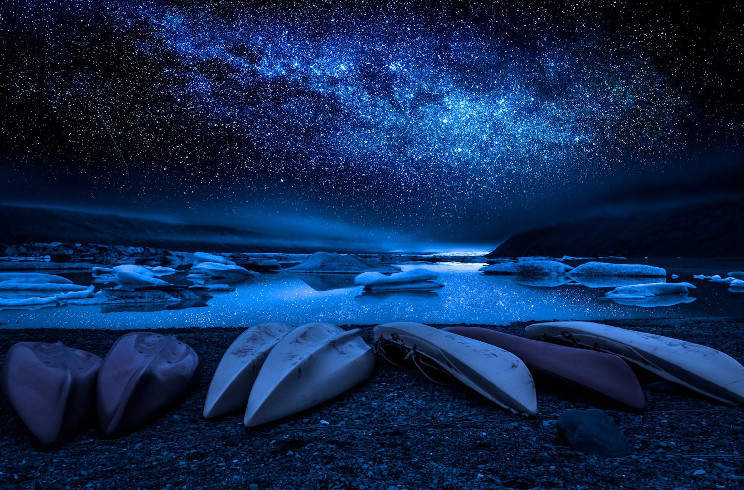 Vintergatan med kanoter i förgrunden